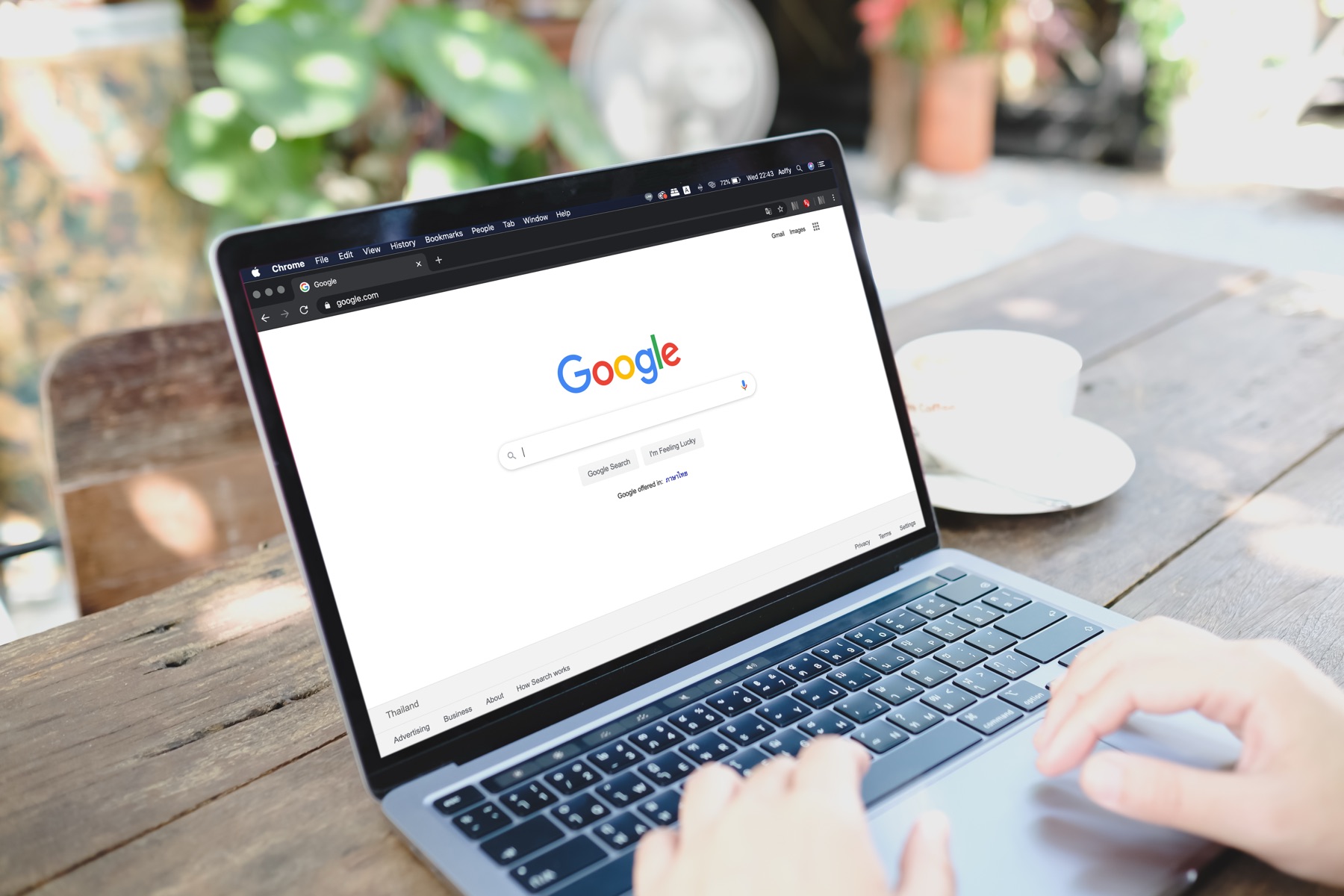 Laptop sa otvorenom Google pretragom na drvenom stolu u bašti