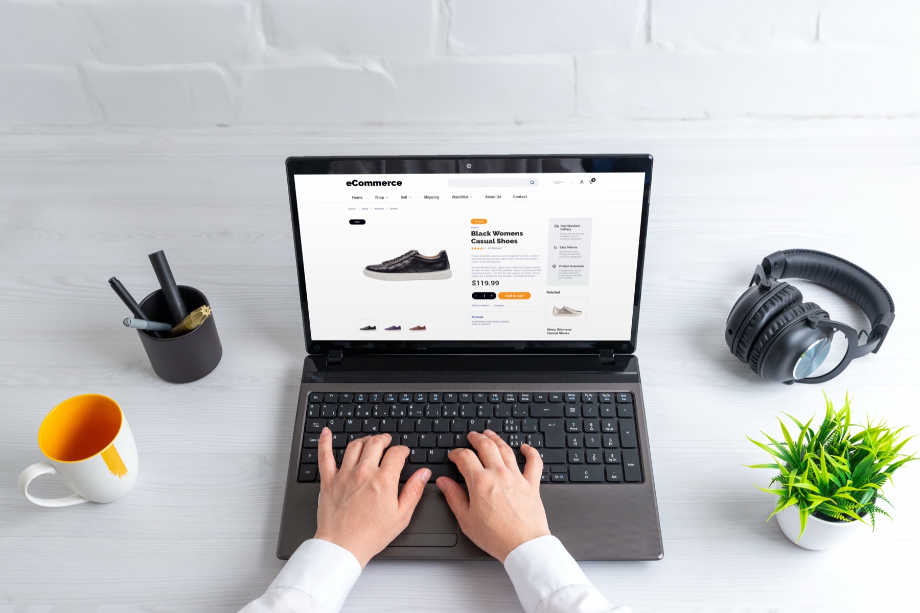 Ruke kucaju na laptopu na kome je otvorena web prodavnica sa ženskim cipelama